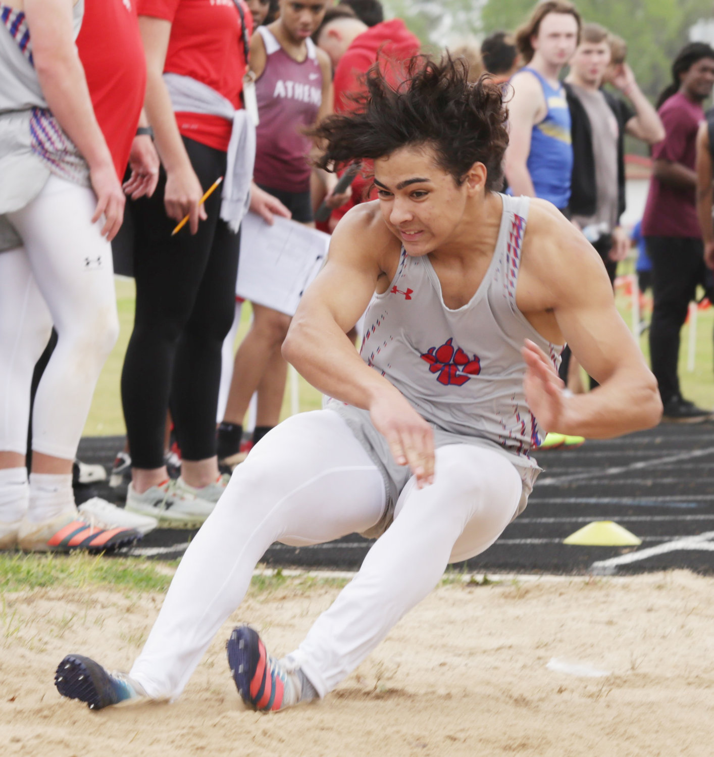 Jake Hallman hits the landing pit in the long jump.